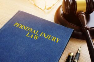 personal injury lawyer Atlanta, GA with gavel, glasses, and personal injury law book sitting on a desk